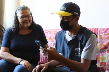 O recenseador, Patrick Emanuel Miranda, entrevista Esméria Jaime do Valle para o censo demográfico 2022, na região central do Rio.